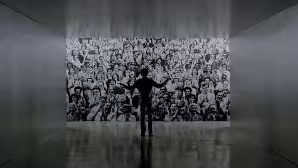 Rupert Pupkin standing with arms outstretched before a large crowd mural