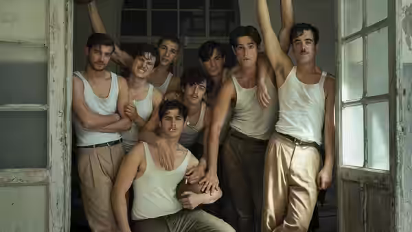 Group of young men in tank tops posing together in a doorway