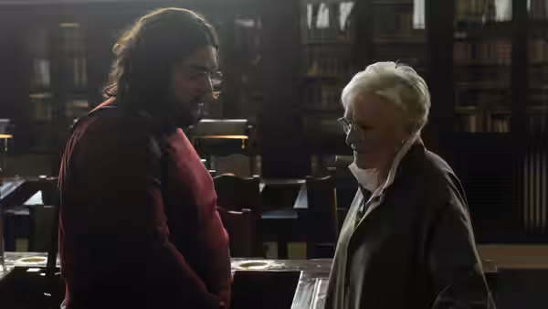 Two men face each other inside a large library