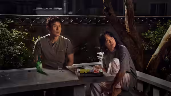 Choi Ho-seok (Sul Kyung-gu) and Ahn Mi-ok (Jeon Do-yeon) at an outdoor table at night