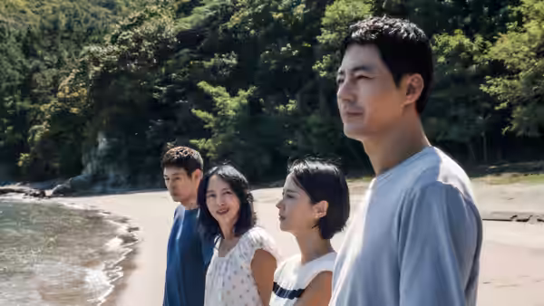 Sang-woo (Zo In-sung) standing on a beach with three companions