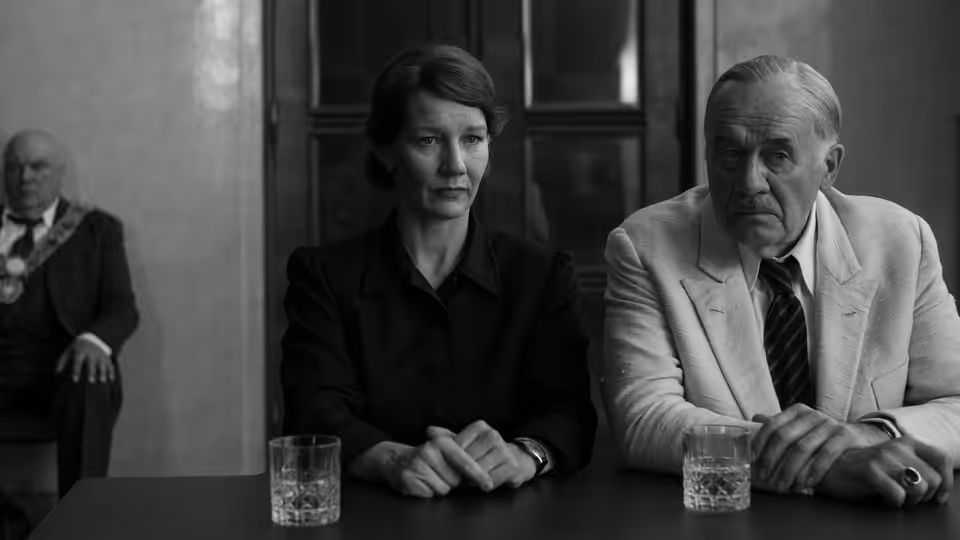 Erika Mann (Sandra Hüller) and Thomas Mann (Hanns Zischler) seated at a table