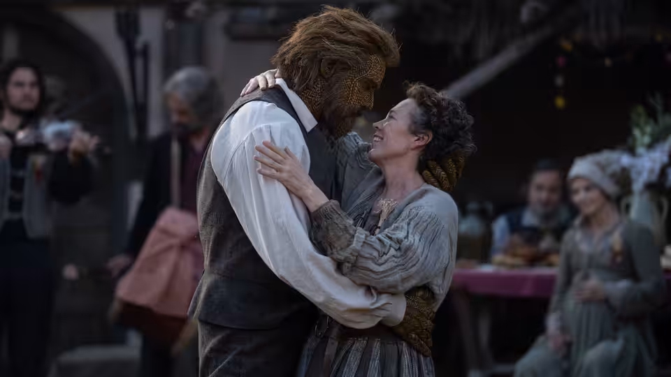 Fisherwoman (Olivia Colman) embraced by Wicker Husband (Alexander Skarsgård) in village square