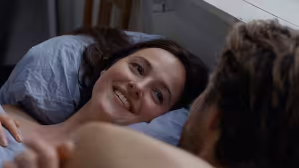 Nora Borg (Renate Reinsve) smiling in bed at a man