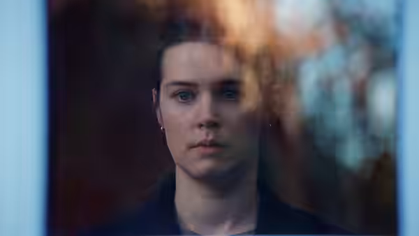 Nora Borg (Renate Reinsve) looking out a window with a serious expression