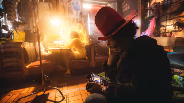 Man in red hat sits in a diner checking his smartphone