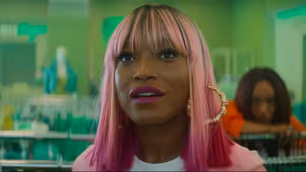Woman with pink hair speaks while standing in a retail store