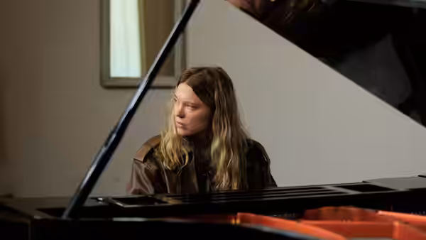 Lucy Weiss (Léa Seydoux) seated at a grand piano in a bright room