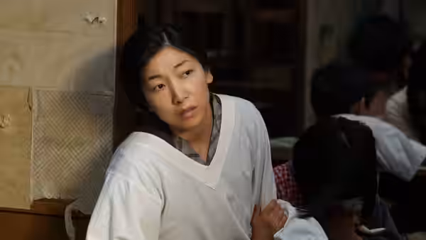 Noriko Oishi (Minami Hamabe) seated indoors against a wall