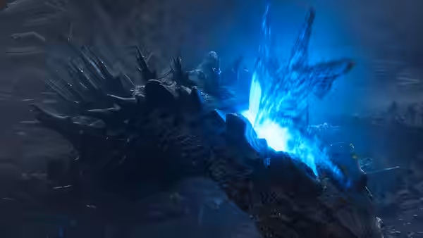 Godzilla's dorsal plates flare with blue energy in the darkness