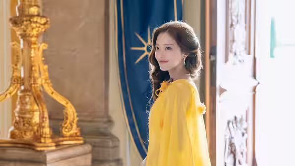 Navier (Shin Min-a) stands in a yellow gown beside an open palace door