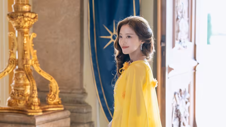 Navier (Shin Min-a) stands in a yellow gown beside an open palace door