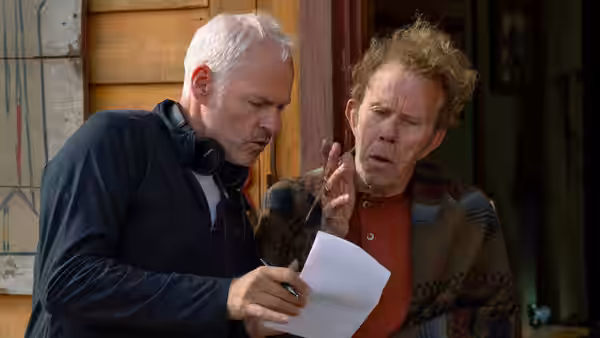 Chris (John Malkovich) studies a sheet of paper beside MJ (Steve Buscemi)