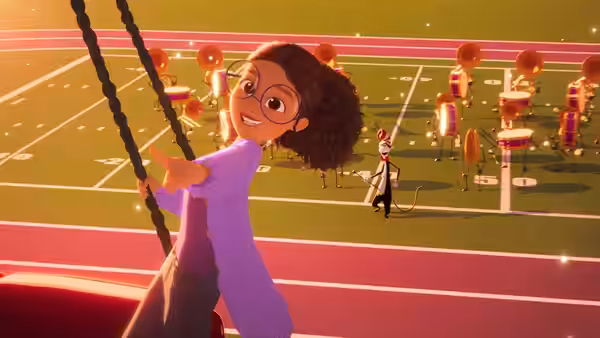 A girl swings from ropes above a football field filled with marching band members