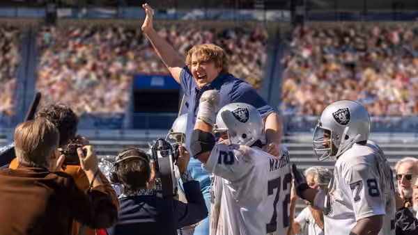 John Madden (Nicolas Cage) celebrates atop Raiders players on the field