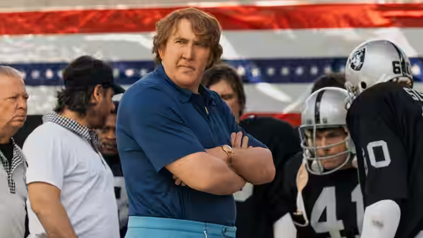 John Madden (Nicolas Cage) stands with Raiders players on the sideline