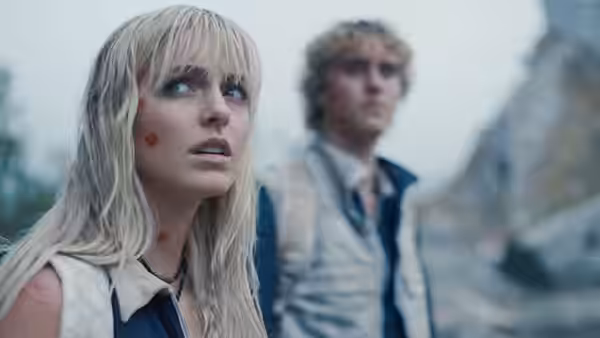 Maysilee Donner (Mckenna Grace) gazing upward with Haymitch Abernathy behind her