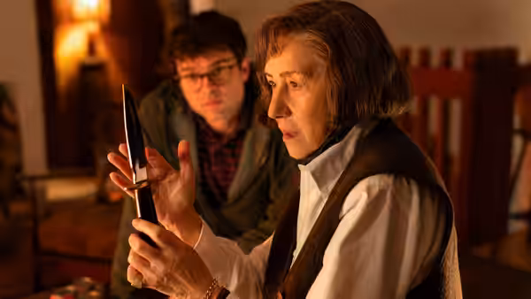 Patricia Highsmith (Helen Mirren) examines a knife as Edward Ridgeway (Alden Ehrenreich) watches