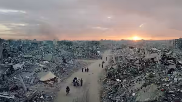 Residents walking through the ruins of a devastated city at sunset