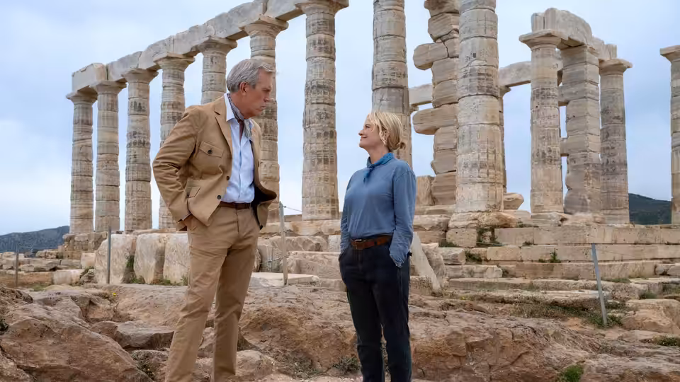 Neville (Hugh Laurie) and Elise (Amy Poehler) facing each other amid ancient ruins