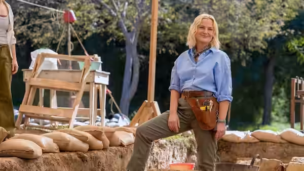 Elise (Amy Poehler) posing with hands on hips at an excavation site