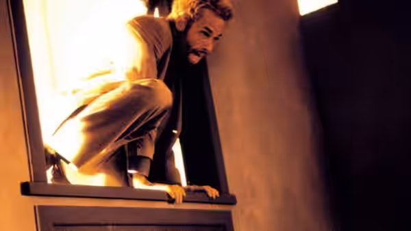 Leonard (Guy Pearce) climbs through an open window into a building