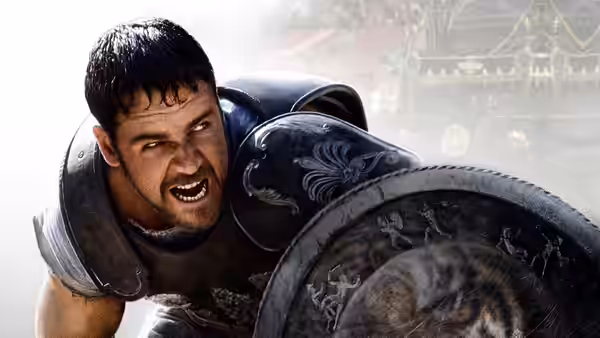 Maximus (Russell Crowe) shouting in armor while holding a decorated shield