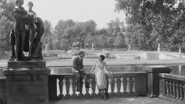 X (Giorgio Albertazzi) and A (Delphine Seyrig) stand beside a statue on a hotel terrace