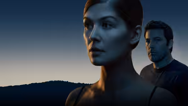 Amy Dunne (Rosamund Pike) gazes into the distance with Nick Dunne (Ben Affleck) behind
