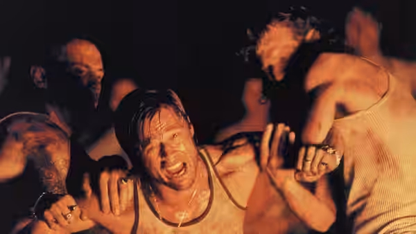 Mickey O'Neil (Brad Pitt) held back by several men in a brawl