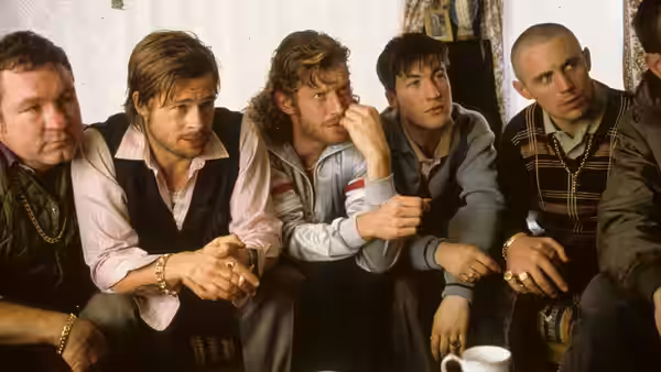 Mickey O'Neil (Brad Pitt) sitting among a group of men indoors