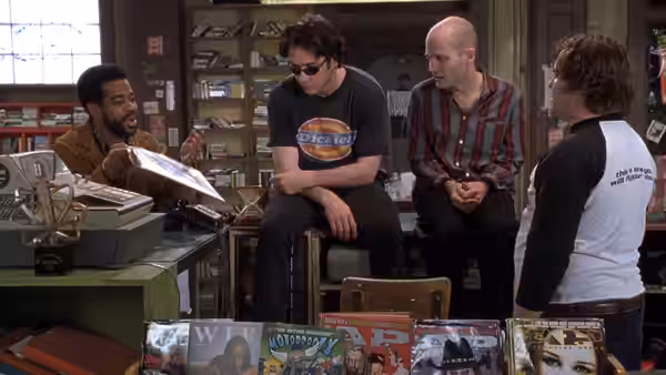 Four people gathered around the counter in a record store