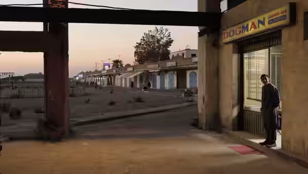 Marcello (Marcello Fonte) stands outside the Dogman grooming shop in a deserted coastal district