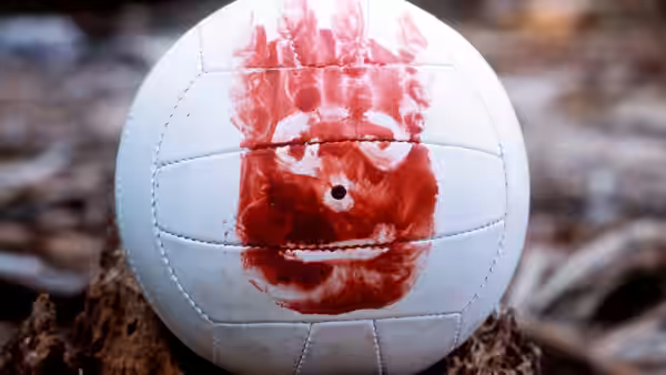 A volleyball with a blood-drawn face resting on the ground