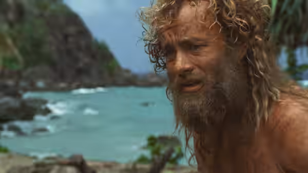 Chuck Noland (Tom Hanks) with long hair and beard on a beach