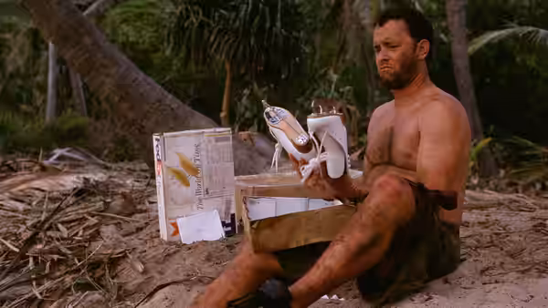 Chuck Noland (Tom Hanks) examining shoes from an open package
