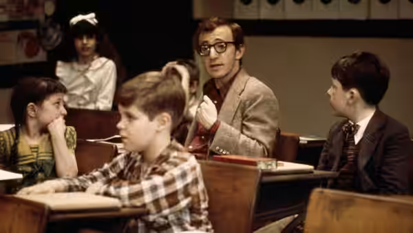 Alvy Singer (Woody Allen) gesturing while teaching students in a classroom