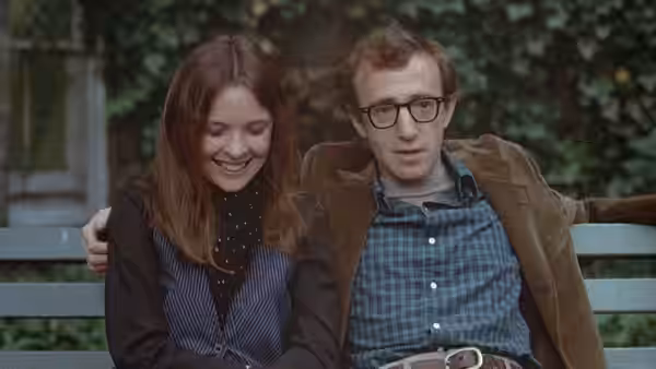 Annie Hall (Diane Keaton) and Alvy Singer (Woody Allen) sitting together on a bench
