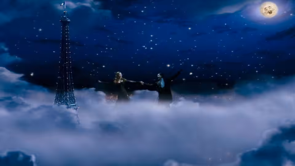 A man and woman stand with arms outstretched on clouds beside the illuminated Eiffel Tower