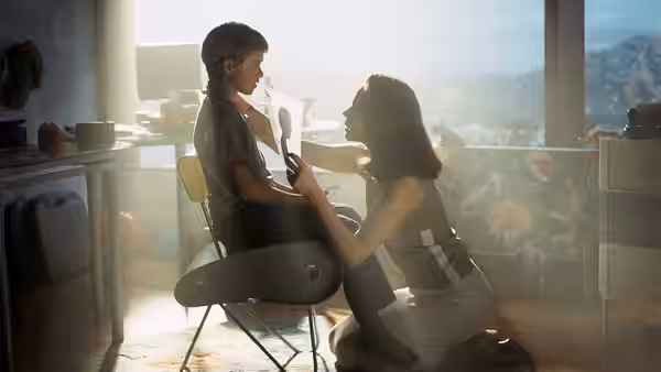 David (Haley Joel Osment) seated as Monica (Frances O'Connor) adjusts his neck in a sunlit room