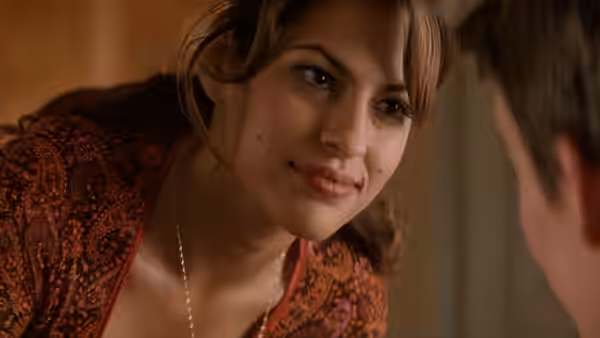 A woman in a patterned top leaning close to a man