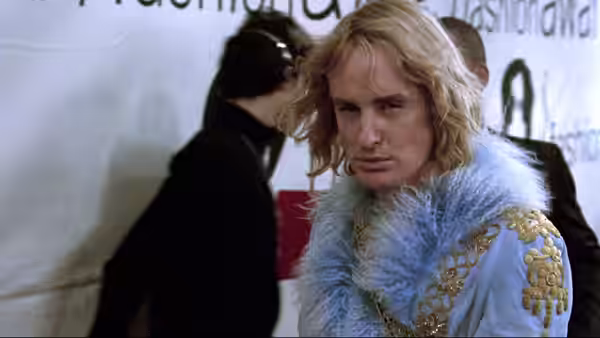 Hansel (Owen Wilson) in blue feathered outfit at a formal event