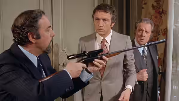 Man aiming a rifle at two men standing in a doorway