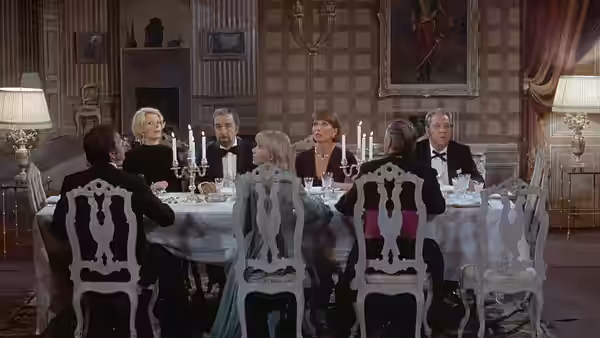Several guests seated around a formal dinner table in a dining room
