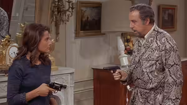 Woman and man each holding a handgun facing one another indoors