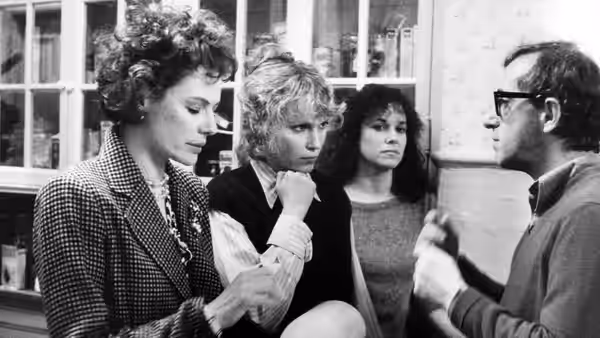 Mickey Sachs (Woody Allen) speaking to three women in an office