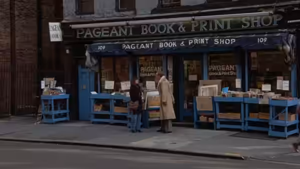 Two people standing outside the Pageant Book & Print Shop