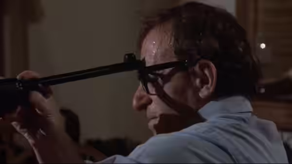 Mickey Sachs (Woody Allen) aiming a rifle from the side
