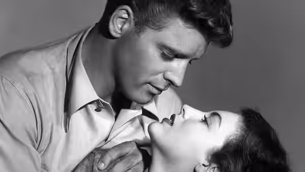 'Swede' Andersen (Burt Lancaster) bends over Kitty Collins (Ava Gardner) as they kiss