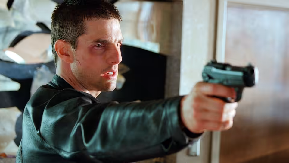 Chief John Anderton (Tom Cruise) aiming a pistol to his right
